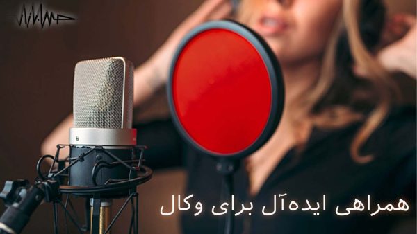 آکادمی صدابازار 21 این تصویر یک نمای حرفهای از میکروفون کاندنسر استودیویی را نشان میدهد که در کنار یک پاپ فیلتر قرمز قرار گرفته است. در پسزمینه، یک خواننده در حال ضبط وکال با تمرکز بالا دیده میشود که حس حرفهای بودن فضای استودیو را منتقل میکند